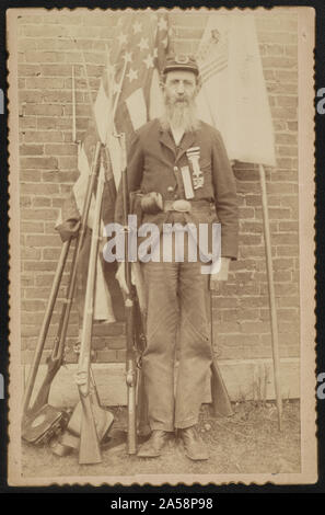 Nicht identifizierte Bürgerkriegveteran von der Grand Armee der Republik Post 386 in Uniform mit muskete vor Flaggen, Waffen und Ausrüstung Stockfoto