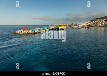 Hafen in Los Cristianos, Teneriffa, Spanien - Mai 25, 2019: Auf der linken Seite - Fähre Fred Olsen auf La Gomera am frühen Morgen in den Hafen von Los Cristianos dock Stockfoto