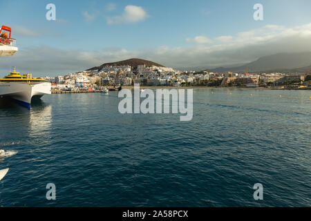 Hafen in Los Cristianos, Teneriffa, Spanien - Mai 25, 2019: Auf der linken Seite - Fähre Fred Olsen auf La Gomera am frühen Morgen in den Hafen von Los Cristianos dock Stockfoto