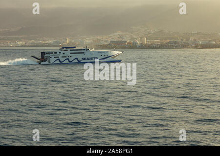 Las Americas, Teneriffa, Spanien - Mai 25, 2019: Blick auf die Küste und die kleine High-speed Fähre aus einer anderen Fähre Abreise für die Insel La Gomer Stockfoto