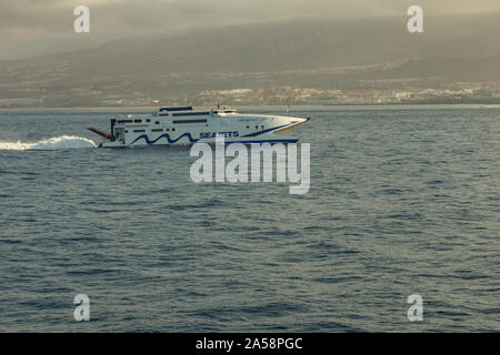 Las Americas, Teneriffa, Spanien - Mai 25, 2019: Blick auf die Küste und die kleine High-speed Fähre aus einer anderen Fähre Abreise für die Insel La Gomer Stockfoto