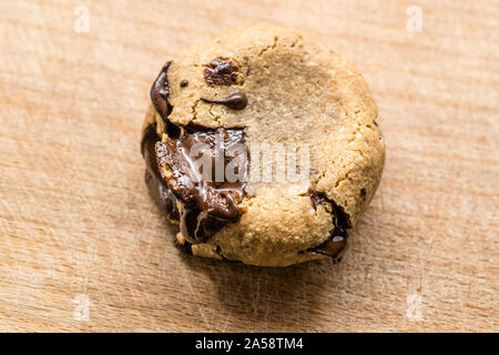 Paleo Chocolate Chip Cookies mit Kokosnuss und Mandeln Mehl auf Holzbrett. Organische Dessert mit geschmolzener Schokolade. Bereit zu Essen. Stockfoto