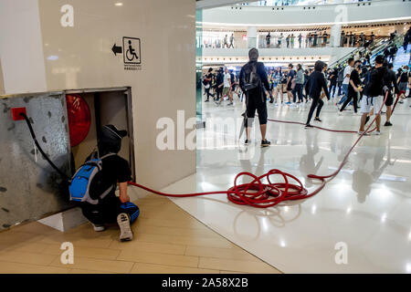 Hong Kong Demonstranten, Ausgehebelt öffnen Sie einen Schrank mit einem Feuerwehrschlauch, sprühen Sie die Öffentlichkeit und die Geschäfte im Inneren einer Shopping Mall in Hongkong Stockfoto