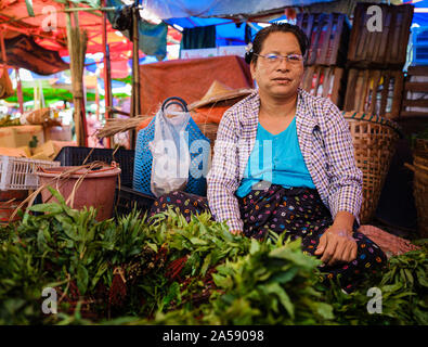 YANGON, MYANMAR - ca. Dezember 2017: Porträt von Frau verkaufen Gemüse am Markt in Yangon. Stockfoto