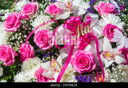 In der Nähe von rosa, weiss und violett Beerdigung Blumen mit dem Wort MA in goldenen Buchstaben Stockfoto