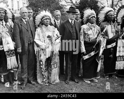 Präsident Calvin Coolidge mit Indianer Kopfschmuck und traditionelle Kleidung Ca. 1900s Stockfoto