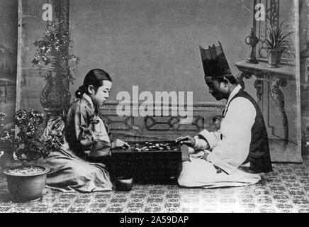 Über ein Spiel (gehen). Mann und Frau auf dem Boden spielen Spiel an Bord sitzen. 1910-1920 Stockfoto