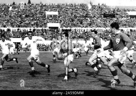 1954 Rugby Union European Cup Finale zwischen Italien und Frankreich im Stadion der 100 000 (jetzt) Stadio Olimpico in Rom. Frankreich gewann das Match 39-12. In diesem Bild der Franzose Roger Martine hält den Ball unterstützt durch seine teammmates Maurice Prat et Gérard Murillo. Italienische Paolo Rosi (links) e Pietro Stivano Versuch, auf dem französischen Angriff zu blockieren. Stockfoto