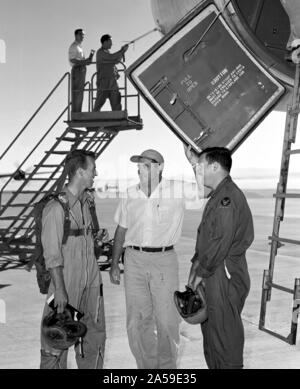 Eine B-47 Stratojet auf Rampe mit Piloten und Crew. Im Jahre 1954, nach einem Flug in die Boeing B-47 Stratojet eine Crew Chief Wilbur McClenaghan (Mitte), fragt der Piloten wenn es gibt keine "quawks', die man vor dem nächsten Flug genommen werden sollte. Piloten Joe Walker auf dem Betrachter überlassen und Stanley Butchart auf der rechten Seite. Data System Techniker Merle Curtis, in Overalls, besetzt ist, Kontrolle der airdata Kopf montiert auf der Nase Ausleger mit Hilfe des Instrumentation Crew Chief Raymond Langley. Die Tür zum Cockpit geöffnet ist, zeigt ein Blick auf die Leiter, die Falten, die von der PI verwendet werden Stockfoto