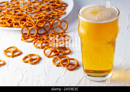 Bier und Brezeln auf weißem Hintergrund Stockfoto
