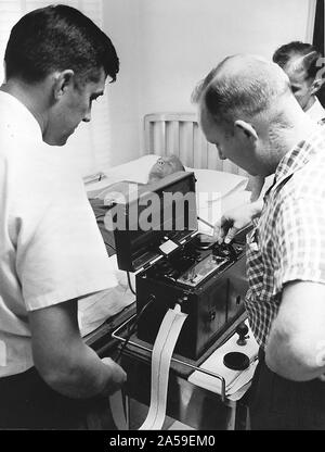 (1961) - - - Astronaut John Glenn Jr. in einem elektrokardiographen von Dr. Jackson während der medizinischen Prüfung im Pensacola Naval Station gemacht. Stockfoto