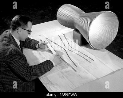 Ein Ingenieur an die Nationale Luft- und Raumfahrtbehörde (NASA) Lewis Research Center untersucht, eine Zeichnung, die Montage und die Details einer 20.000 Pfund Schub regenerativ gekühlten rocket Motor. Stockfoto