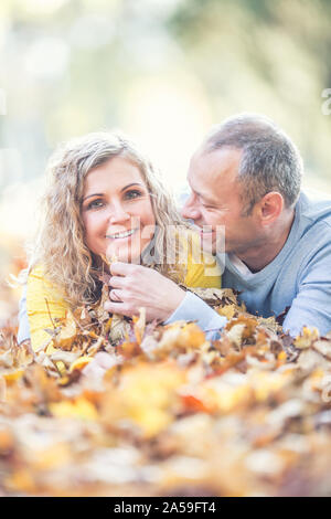 Gerne älteres Paar im Herbst Ahorn Blätter liegen. Stockfoto