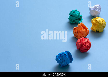 Zerknüllt buntes Papier Seiten auf blauem Hintergrund. Stockfoto