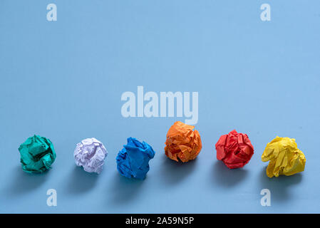 Zerknüllt buntes Papier Seiten auf blauem Hintergrund. Stockfoto