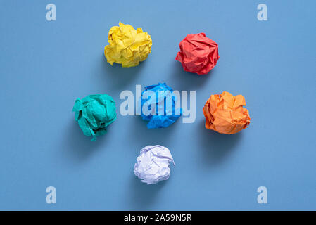 Zerknüllt buntes Papier Seiten auf blauem Hintergrund. Stockfoto