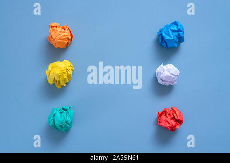 Zerknüllt buntes Papier Seiten auf blauem Hintergrund. Stockfoto