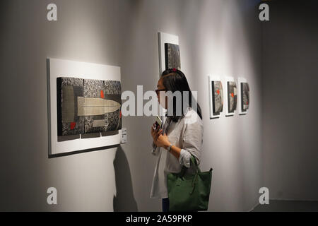 (191019) - JINGDEZHEN, Oktober 19, 2019 (Xinhua) - eine Frau besucht eine Porzellan Keramik Ausstellung während einer Messe in Jingdezhen, der ostchinesischen Provinz Jiangxi, Okt. 18, 2019. Die fünf Tage, 2019 China Jingdezhen International Keramik Messe eröffnet am Freitag, zieht fast 1.000 Porzellan Firmen aus dem In- und Ausland. (Xinhua / Zhou Mi) Stockfoto