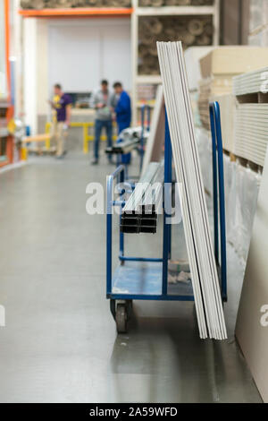 Trolley in einem Hardware-store mit Baumaterial geladen. Reparatur und Konstruktion Konzept. vertikale Foto. Stockfoto