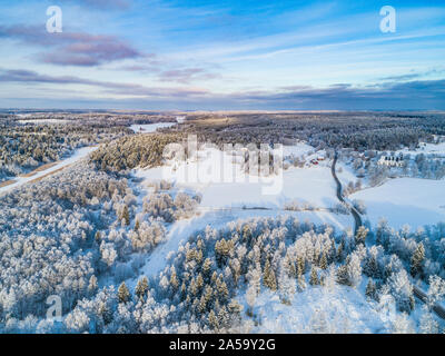 Arial drone Ansicht einer Winterlandschaft in Schweden, Skandinavien. Es ist eine typische Landschaft, mit einer Straße, einer Kirche, einem zugefrorenen Fluss, Wald und op Stockfoto