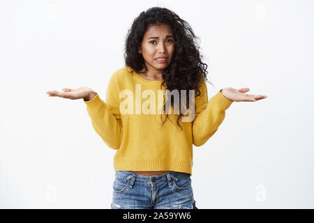 Oops Mädchen sagt es tut uns Leid. Cute silly afrikanische amerikanische Frau, lockiges, schwarzes Haar, zuckte mit den Händen, seitwärts, runzelte die Stirn und schrie, als Gefühl sorgen Stockfoto