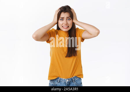 Erschrocken oder Verlegen junge attraktive Frau, grab Kopf Zusammenbeißen der Zähne in Panik und Angst, etwas sehen, was gefährlich oder beschwerlich, klemmt in der difficuly Stockfoto