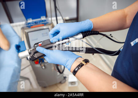 Kosmetologie Service. Junge Frau von Schönheit Klinik Arzt in Handschuhe close-up einstellen Laser zur Haarentfernung Stockfoto