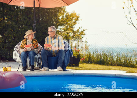 Lächelnd senior Freunden Spaß haben zusammen und Wassermelone Essen Stockfoto