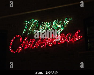 Frohe Weihnachten Zeichen leuchtende Buchstaben auf schwarzem Hintergrund Stockfoto