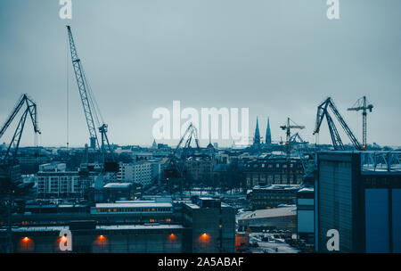 Bild des Flusses, Schwimmkrane, Gebäude am Flussufer in Abend Stockfoto