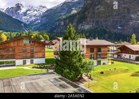Bunte Holzhäuser in Kandersteg Dorf, Kanton Bern, Schweiz, Europa und Schnee Berge Panorama Stockfoto