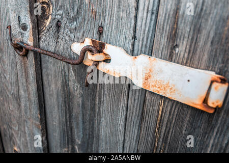 Alte und rostige Haken verriegelt das alte vertrocknete hölzerne Scheunentor Stockfoto