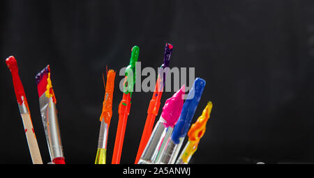 Malerei Konzept. Pinsel mit bunten Farben auf schwarzem Hintergrund, Detailansicht, kopieren Raum Stockfoto