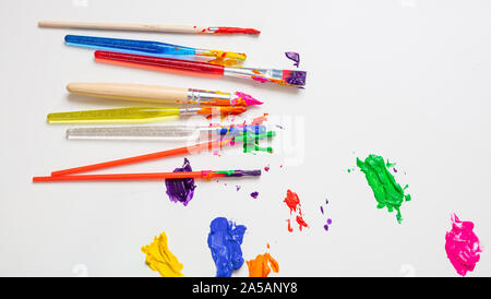 Kinder Kreativität. Bunte finger Farben und Pinsel auf die weiße Farbe, Hintergrund, Ansicht von oben, kopieren Raum Stockfoto