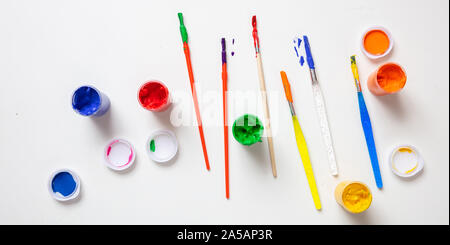 Kinder Kreativität. Bunte finger Farben und Pinsel auf die weiße Farbe, Hintergrund, Ansicht von oben Stockfoto