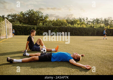 Zwei männliche Fußballspieler ruht auf dem Gras Stockfoto