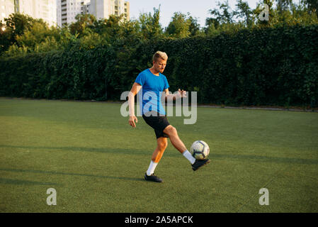 Männliche Fußballspieler mit Ball stehend auf Linie Stockfoto