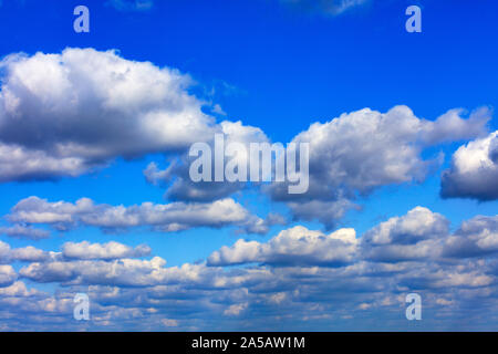 Ein Hintergrund der blaue Himmel gesättigt mit der Textur der weißen, grauen und flauschige Wolken am Horizont. Stockfoto