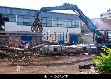 Blick auf Maschine, Lader Manipulator mit hydraulischer grappling Kralle bis sammelt, Verschieben von alten Stahl, Schrott. Stockfoto