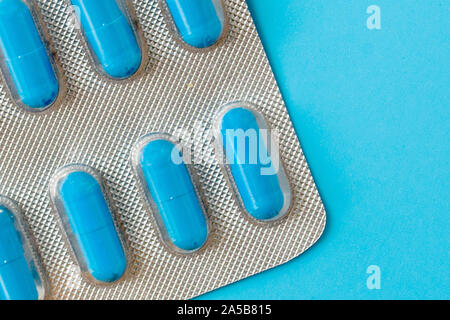 Medikamente, Pillen, Thermometer, traditionelle Medizin für die Behandlung von Erkältungen, Grippe, Wärme auf einem blauen Hintergrund. Aufrechterhaltung der Immunität. Saisonale Krankheiten. Stockfoto