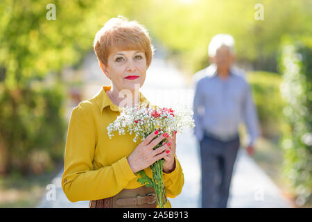 Eine ältere Frau wartet auf ihren geliebten Mann ihr zu nähern. Stockfoto