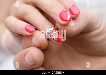 Hand der Bräutigam einen Ring am Finger seiner Braut, Nahaufnahme Stockfoto