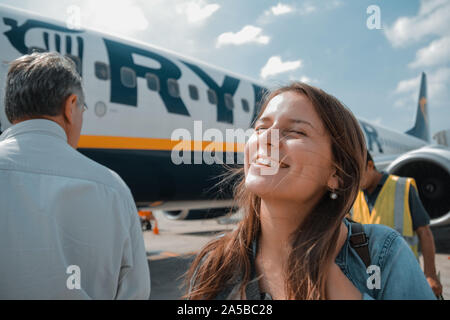 Bergamo, Italien - Oktober 05, 2018: eine junge Frau steht neben der Ryanair Flugzeug, Warten auf Boarding an einem sonnigen Tag. Reiseziel Stockfoto