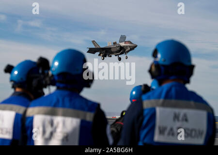 Die Royal Navy F-35B Blitz Stealth Fighter Aircraft führt eine vertikale Landung auf dem Flugdeck der HMS Queen Elizabeth während des Flugbetriebs am 17 Oktober, 2019 in den Atlantischen Ozean. HMS Queen Elizabeth, ist das größte Kriegsschiff der Royal Navy gebaut und wird derzeit zur Unterstützung der Übung eingesetzten WESTLANT 19. Stockfoto