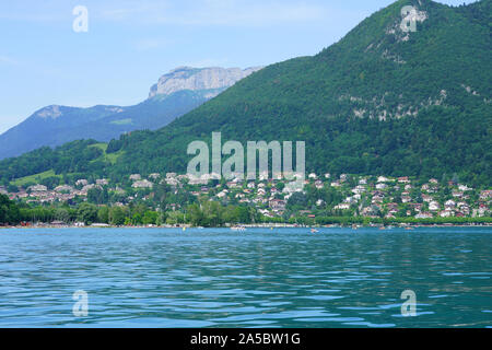 ANNECY, FRANKREICH-24 Jun 2019 - Ansicht von Veyrier-du-Lac und die bergregion von einem Boot auf den See von Annecy in Annecy, Haute Savoie, Frankreich gesehen. Stockfoto