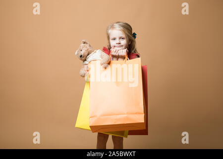 Ein junges Mädchen im roten Kleid und mit Einkaufstüten, Happy Shopping Stockfoto