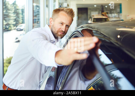 Eine männliche Käufer sitzt in einem neuen Auto. Stockfoto