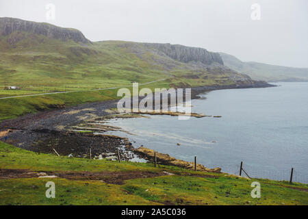 Eine Straße erstreckt sich in der Ferne auf einem grauen nebeligen Tag an der Nordküste der Trotternish, auf der Insel Skye in Schottland, in der Nähe des Weilers von duntulm. Stockfoto