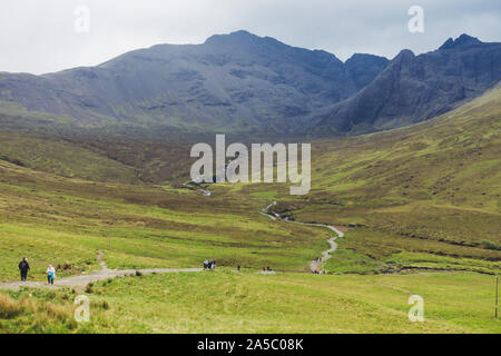 Ein Wanderweg schlängelt sich durch die Wiese an der Fairy Pools, einer berühmten Touristenattraktion auf der Insel Skye, Schottland, Großbritannien Stockfoto