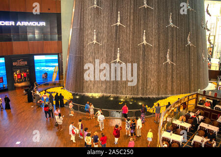 Dubai/VAE - Oktober 19, 2019: Der Wasserfall in der Dubai Mall mit vielen Menschen, weltweit größte Shopping Mall. Menge in der Dubai Mall, Ansicht von oben Stockfoto